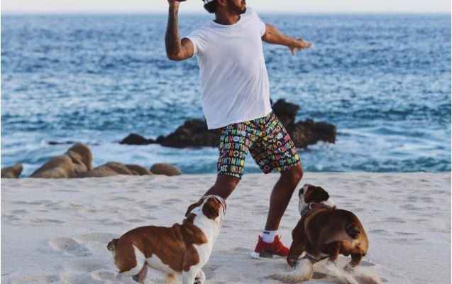 هاميلتون يلعب الرغبي مع كلبيه على شواطئ المكسيك
